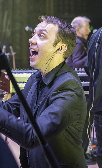 William Sauerland leads the choir at a Pink Droyd concert in the Embassy Theatre.